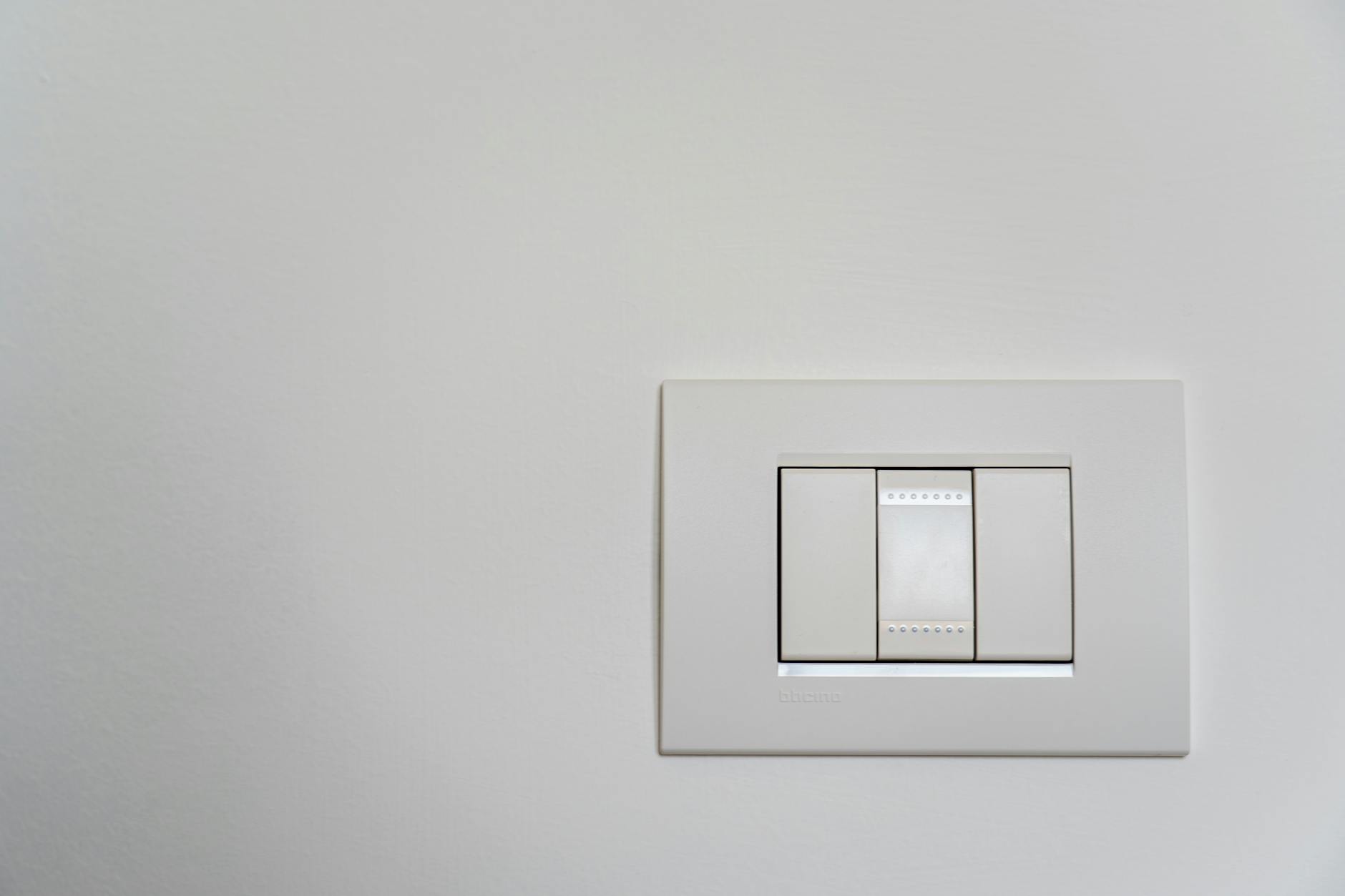 1. Upgrade Your Light Switch Plates to Decorator Style — $8 - Close-up of a modern white light switch on a clean wall.
