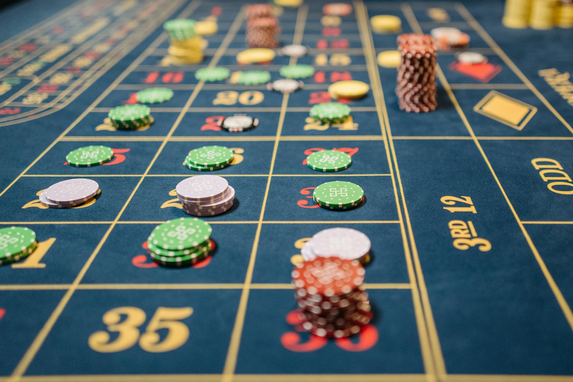 11. Use Odd Numbers in Decor Arrangements - Close-up of a roulette table with colorful poker chips, capturing the thrill of 