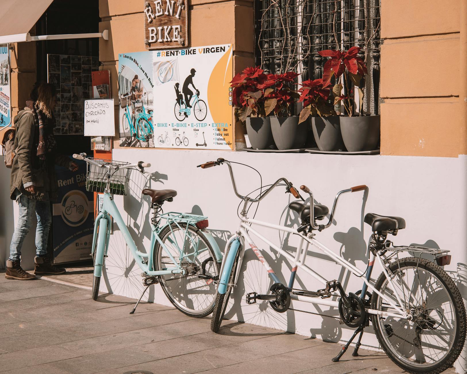 9. Plants — The Cheapest, Best Rental-Friendly Decor - Bicycles parked outside a rental shop in Valencia, Spain on a sunny day.