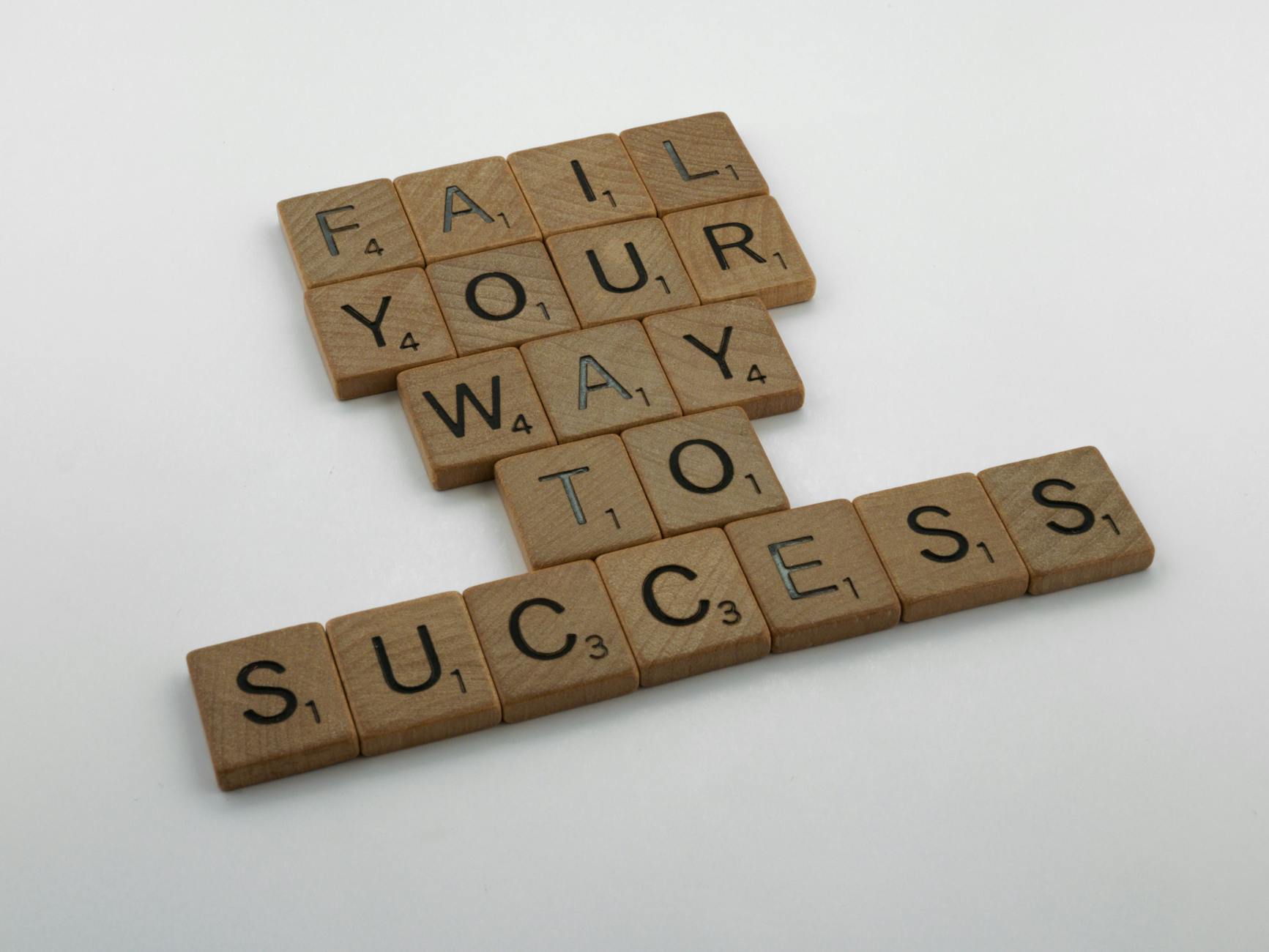 The 11 Hacks That Failed - Wooden tiles spell 'Fail Your Way to Success' emphasizing perseverance.