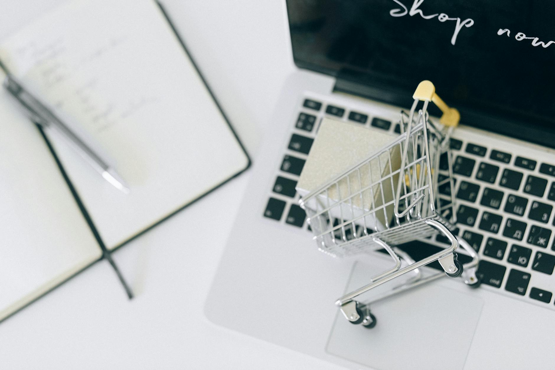 The 5 “Buy-It-Now” Categories - Creative depiction of online shopping with a miniature cart on a laptop keyboard